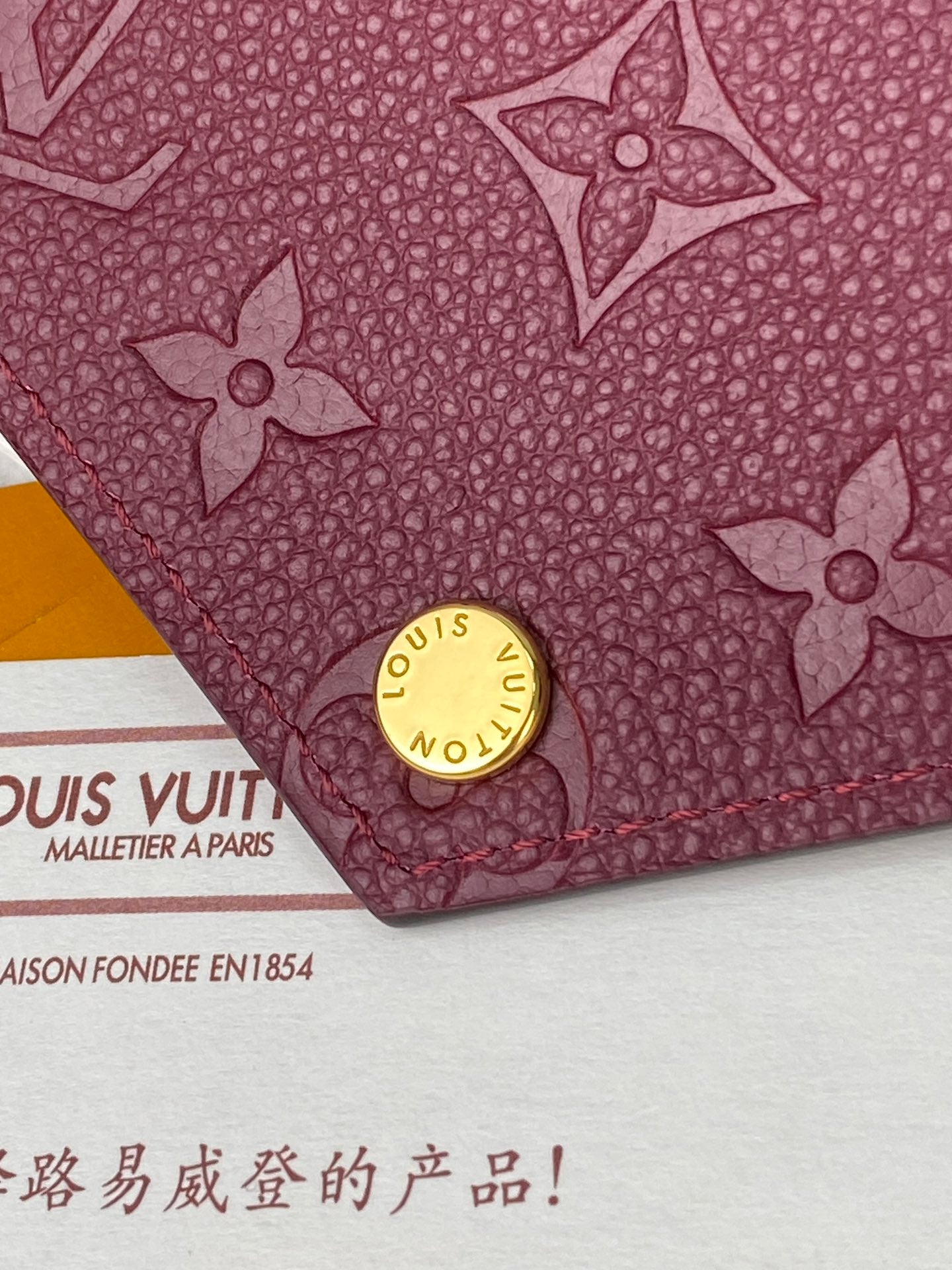 Louis Vuitton small monogram pouch bag close-up in burgundy with gold snap stud