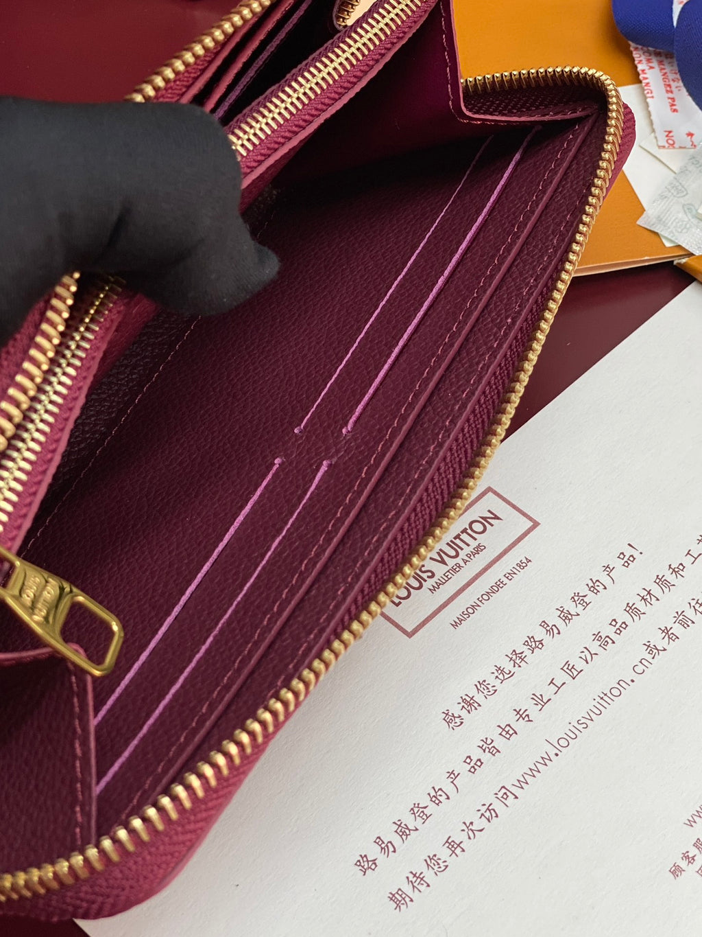 Small purple Louis Vuitton monogram bag interior with gold zipper track and stitched lining.
