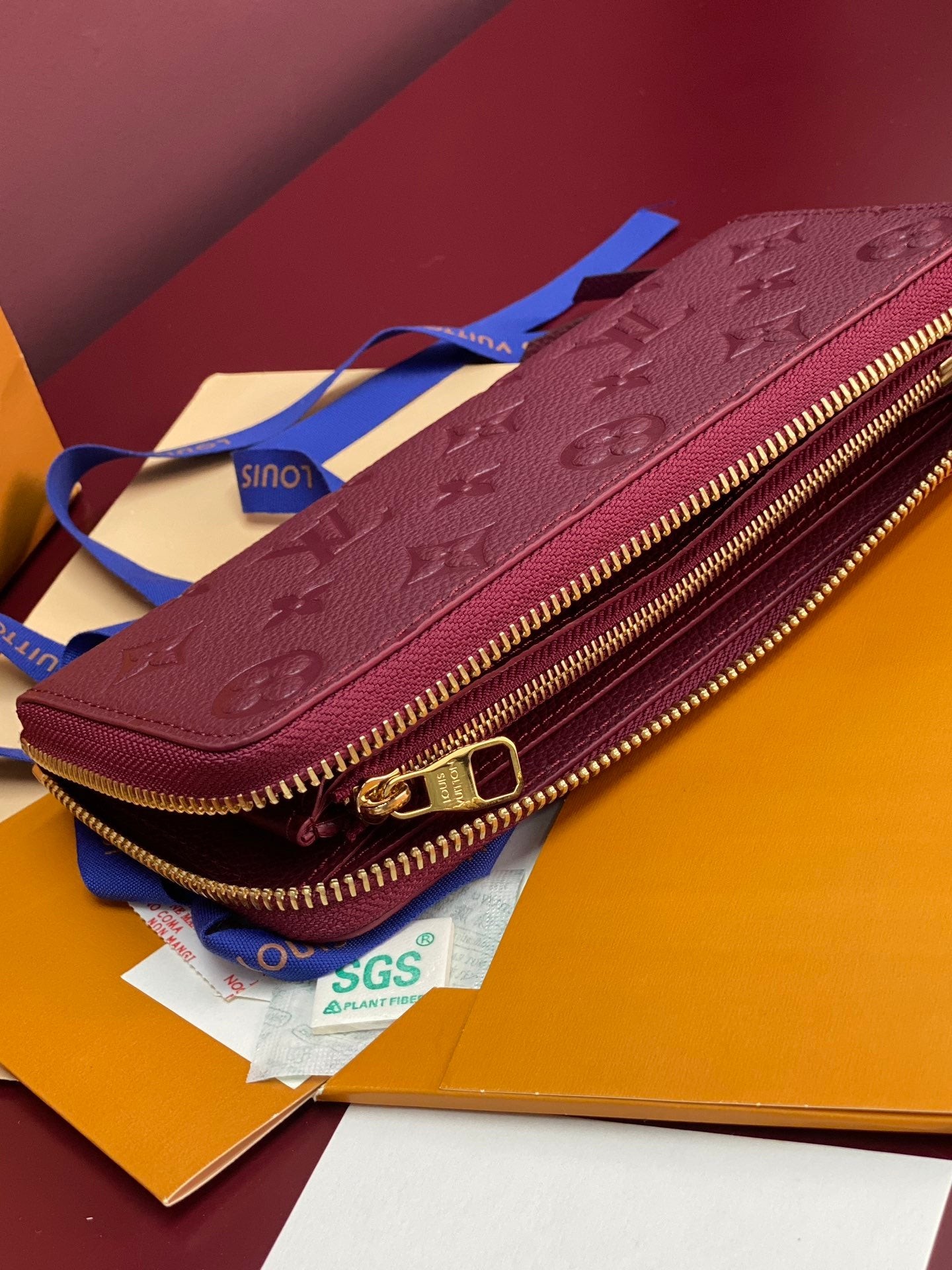 Small purple Louis Vuitton monogram zip bag with gold hardware and wrist strap.