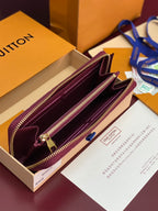 Small purple Louis Vuitton monogram bag opened, showing burgundy interior and gold zippers.