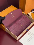 Small bag with burgundy/purple embossed monogram and gold-toned hardware, open front.