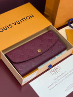 Small bag with flap and burgundy/purple embossed monogram, gold snap button closure.