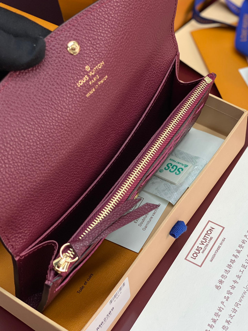 Small bag interior view with burgundy/purple leather, gold zipper and card slot pocket.