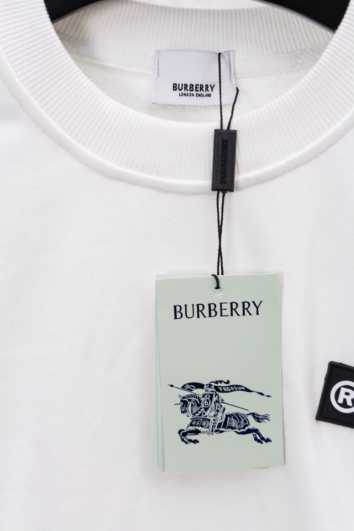 White crewneck sweatshirt collar with attached hang tags