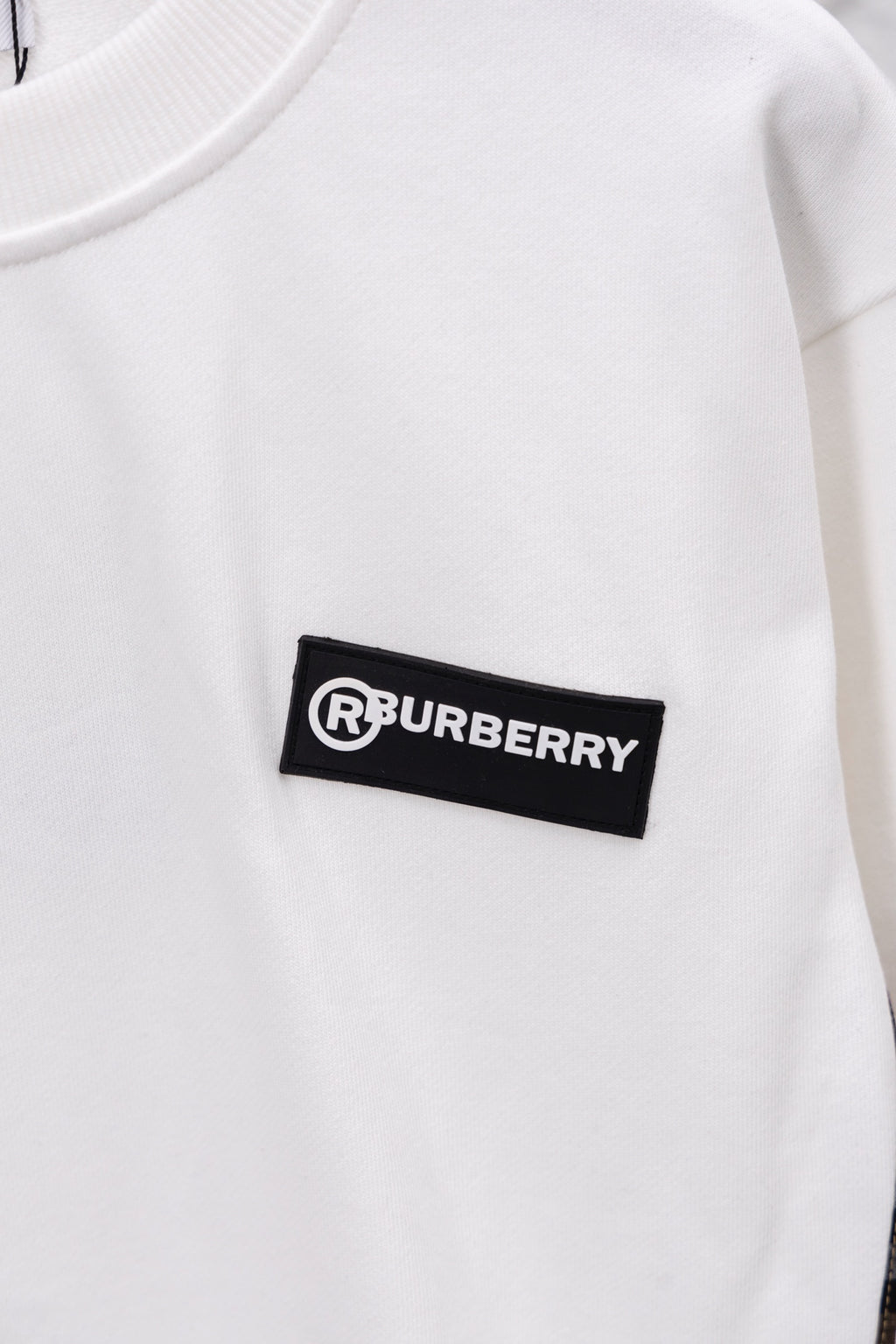 White sweatshirt chest with black logo patch
