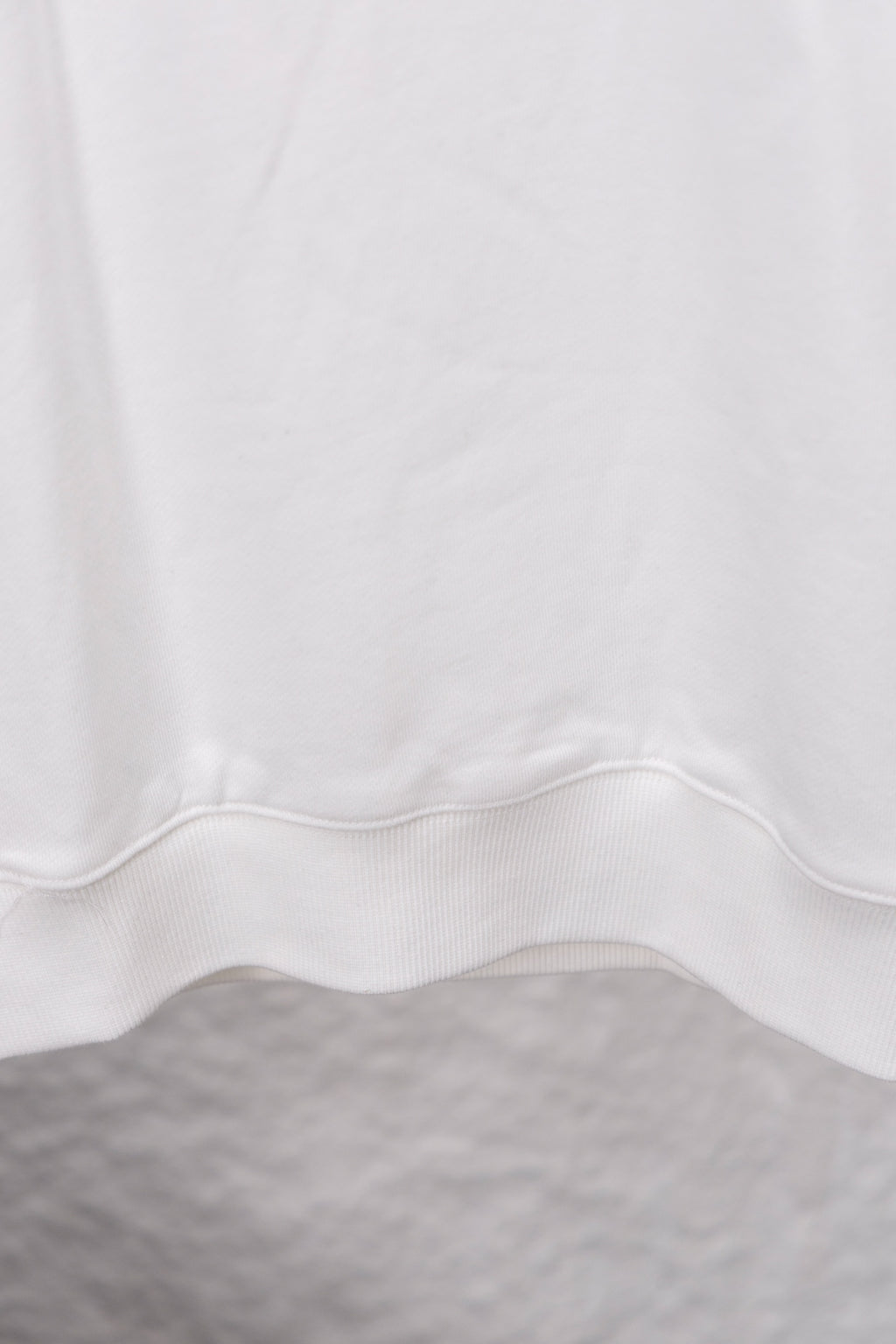 White sweatshirt hem with center seam and ribbed cuff detail
