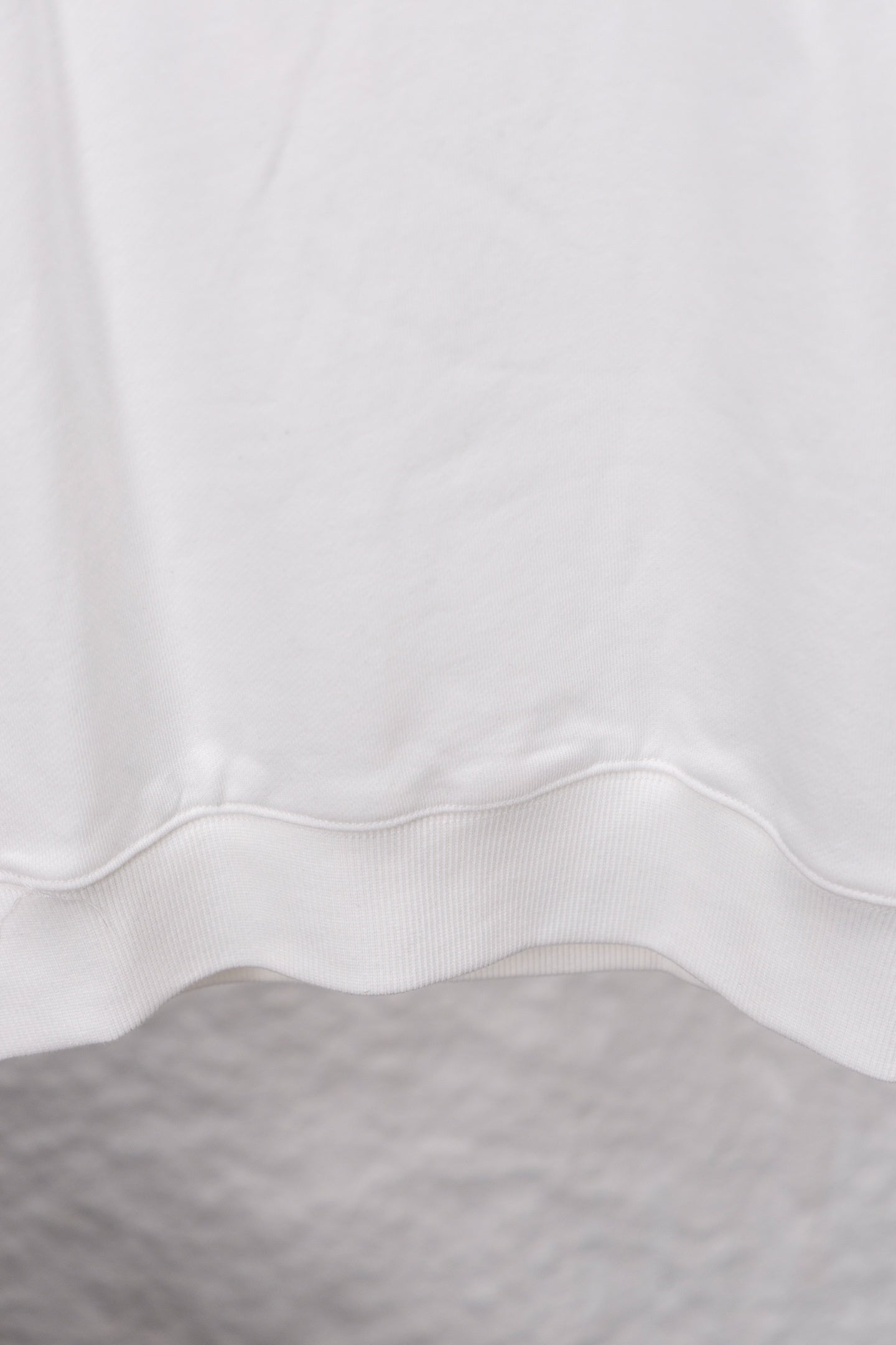 White sweatshirt hem with center seam and ribbed cuff detail