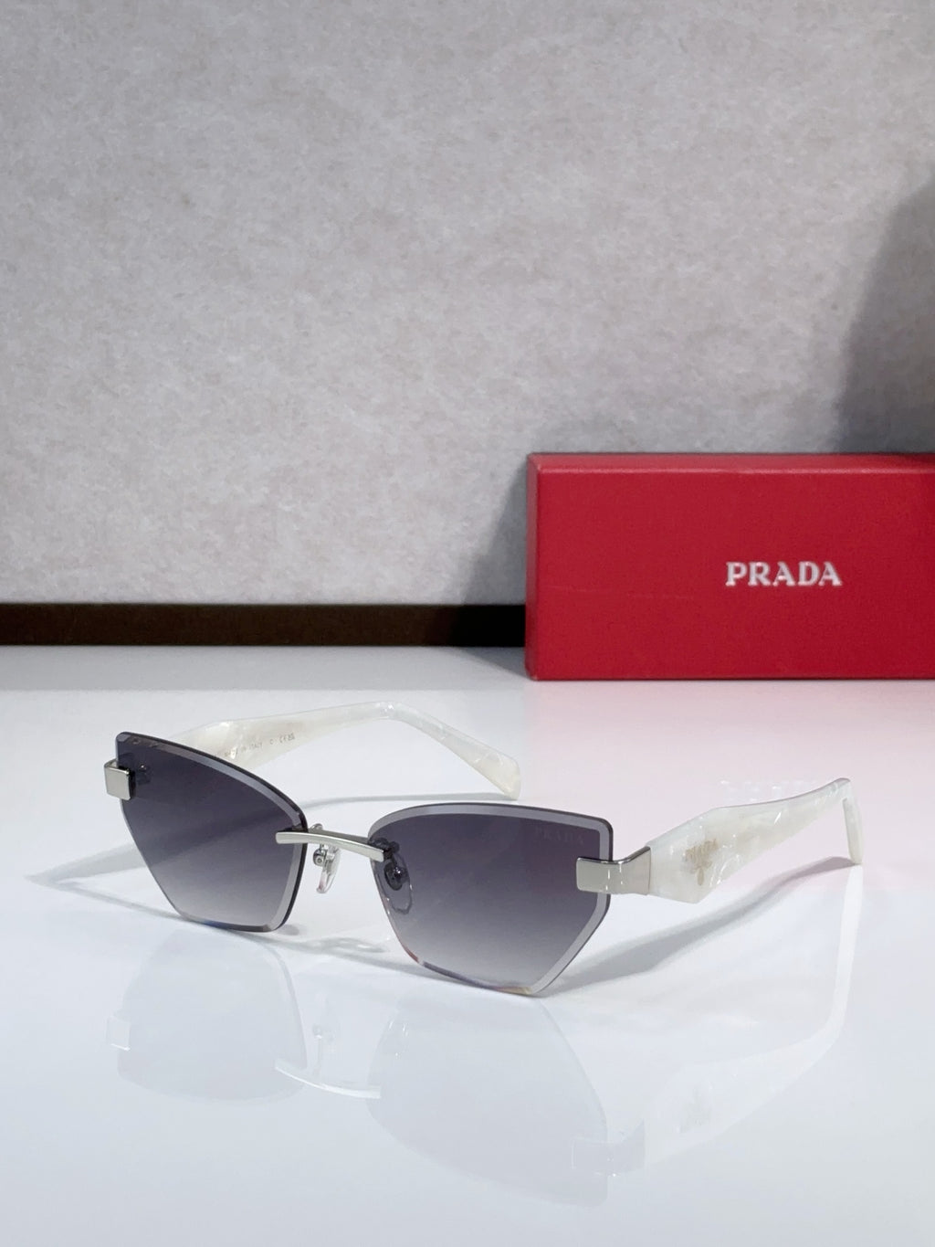 Cat-eye sunglasses with light-colored temples and gold-tone metal frame, light gray lenses