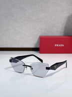 Cat-eye sunglasses with dark frame and black temples, gold-tone bridge, clear to gray lenses