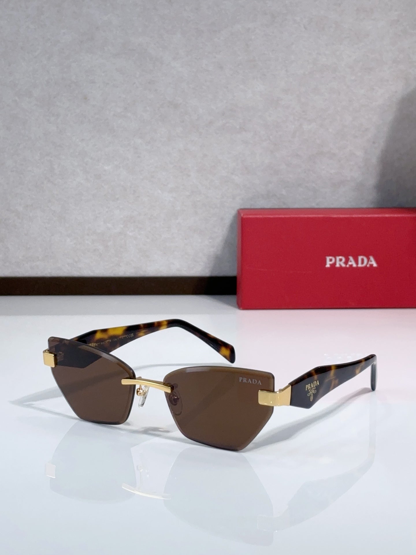 Cat-eye sunglasses with tortoise-pattern temples and gold-tone frame, brown tint lenses