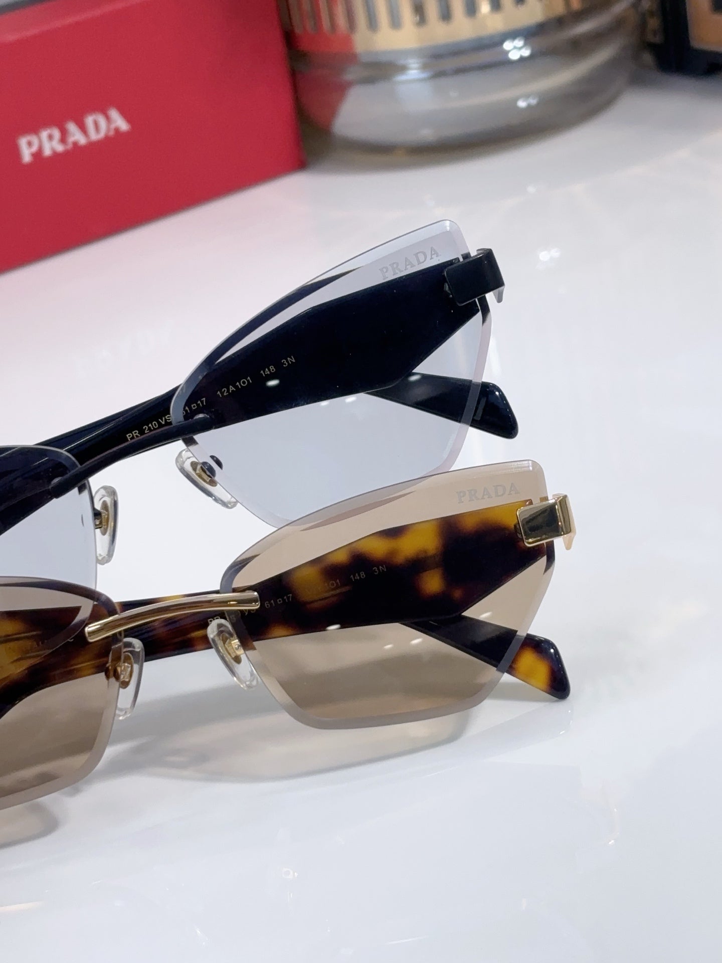 Close-up of cat-eye sunglasses showing tortoise temple and gold-tone hinge, logo details