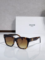 Dark tortoiseshell sunglasses with gold logo on temples and tinted gradient lenses