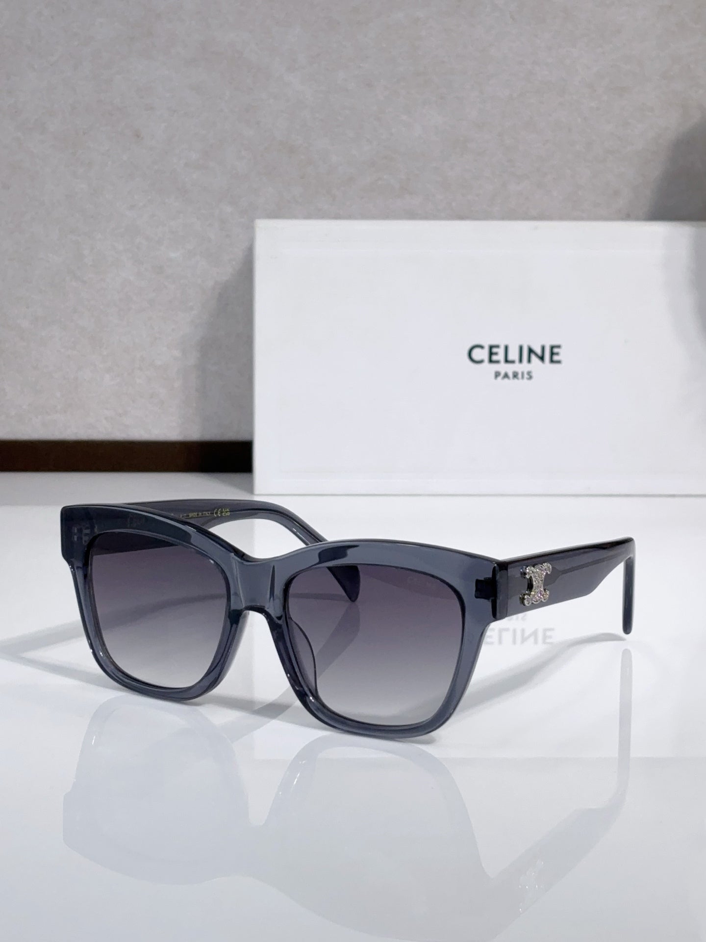 Black sunglasses with oversized lenses and gold logo on side