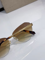 Bvlgari sunglasses close-up with brown tint lenses and gold metal frame