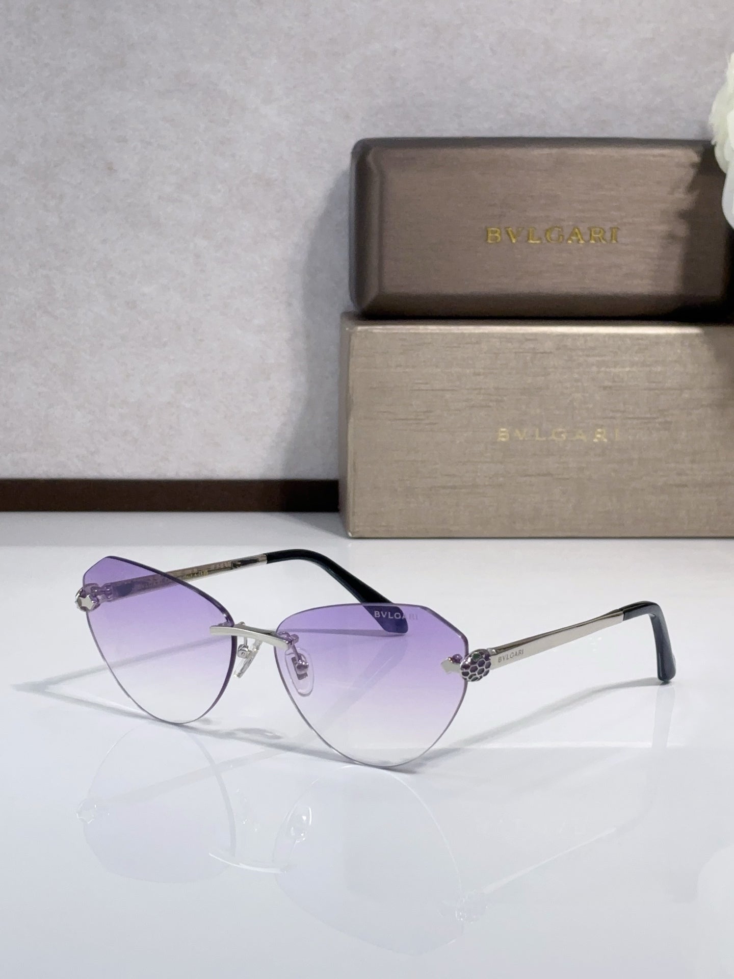 Bvlgari sunglasses with purple gradient lenses, gold metal frame, black temples
