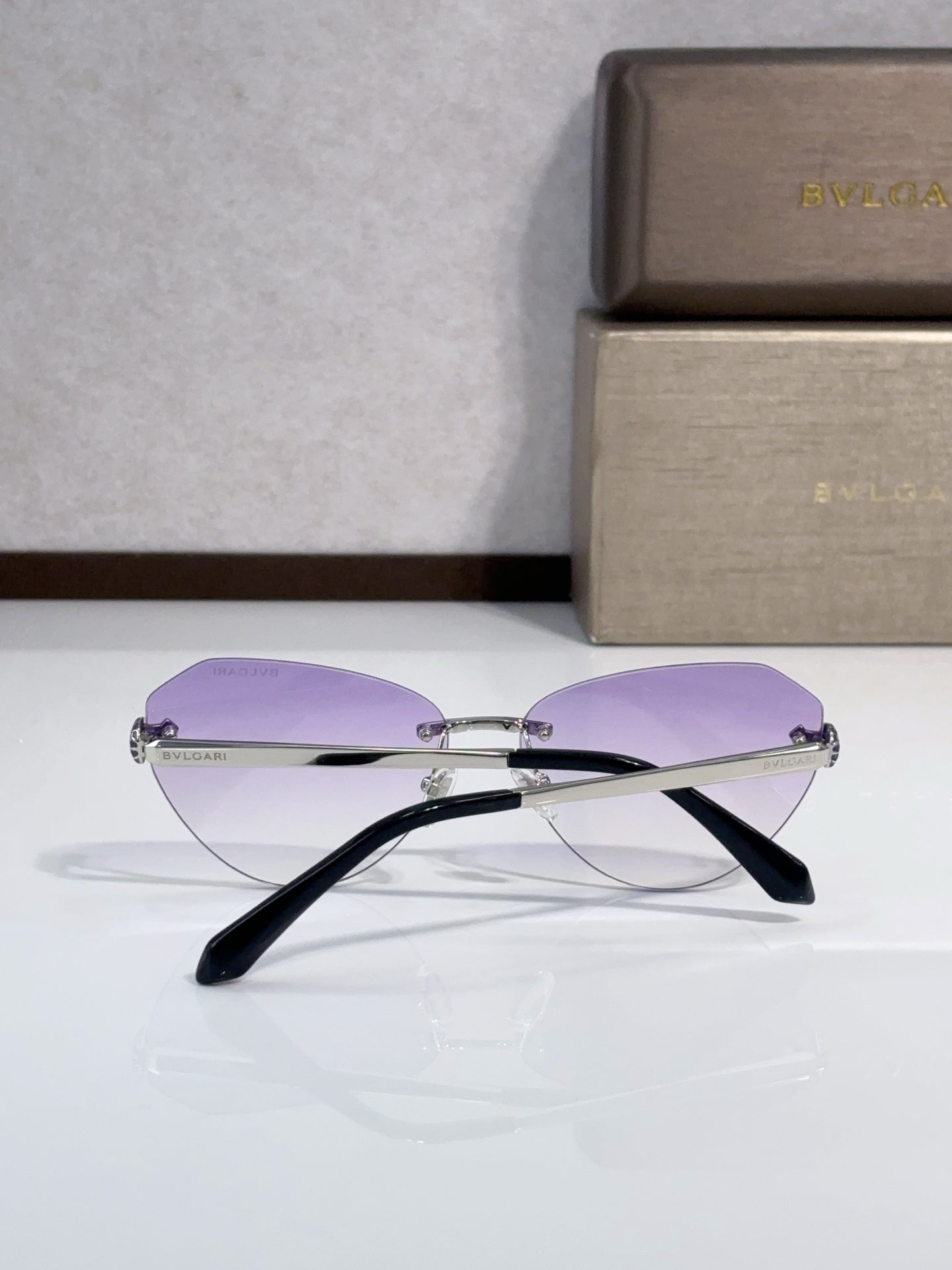 Bvlgari sunglasses side view with purple lenses and black temples, gold metal frame