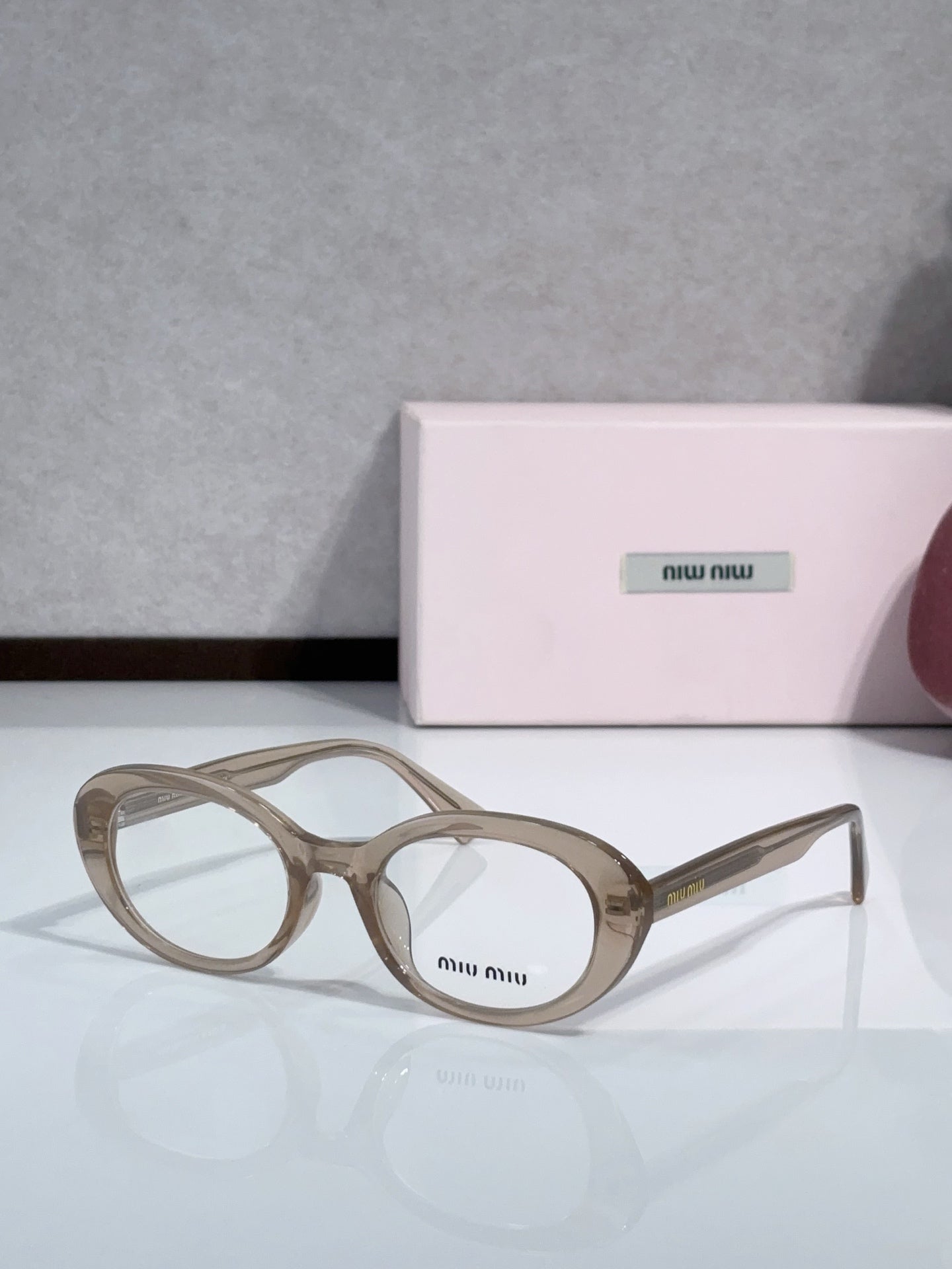 MiuMiu glasses with taupe round frames and clear lenses