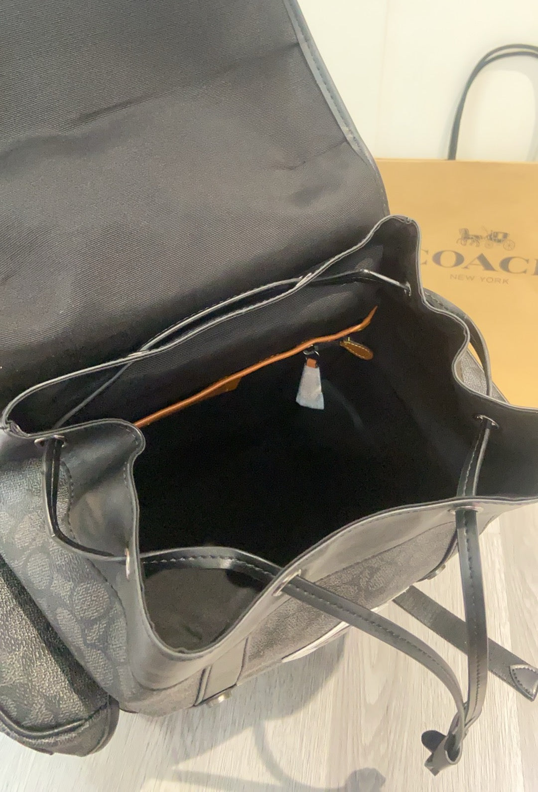 Coah dark monogram backpack interior opening with black lining and shoulder strap