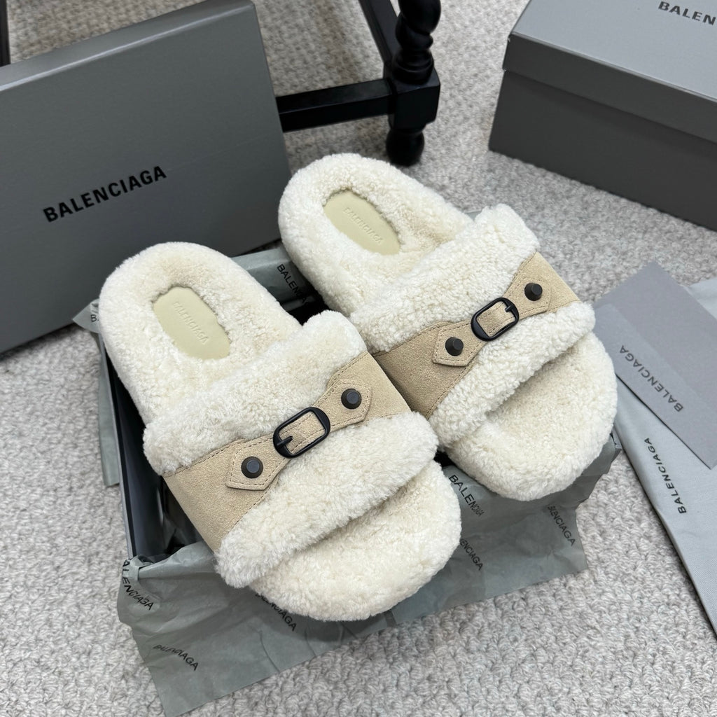 Faux-shearling slide sandals with tan strap and black buckle, cream exterior.