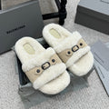 Faux-shearling slide sandals with tan strap and black buckle, cream exterior.