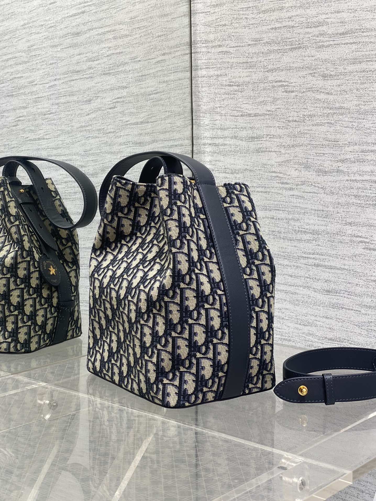 Dior Oblique canvas bucket bag with navy leather strap and gold-tone hardware