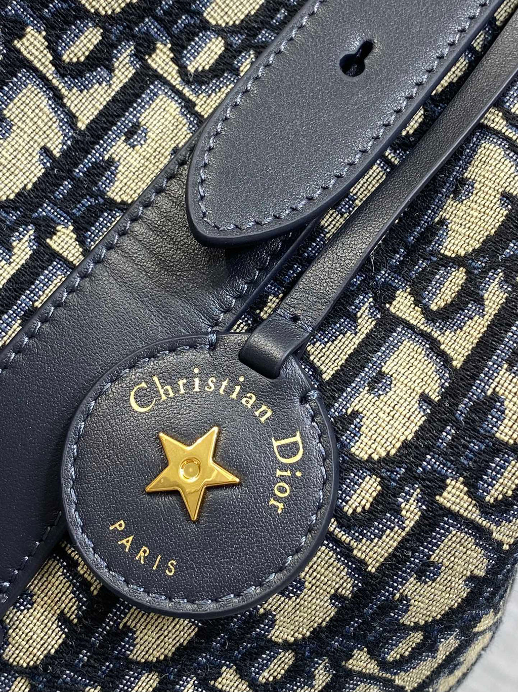 Christian Dior Paris star charm on navy leather strap with 'Made in Italy' text