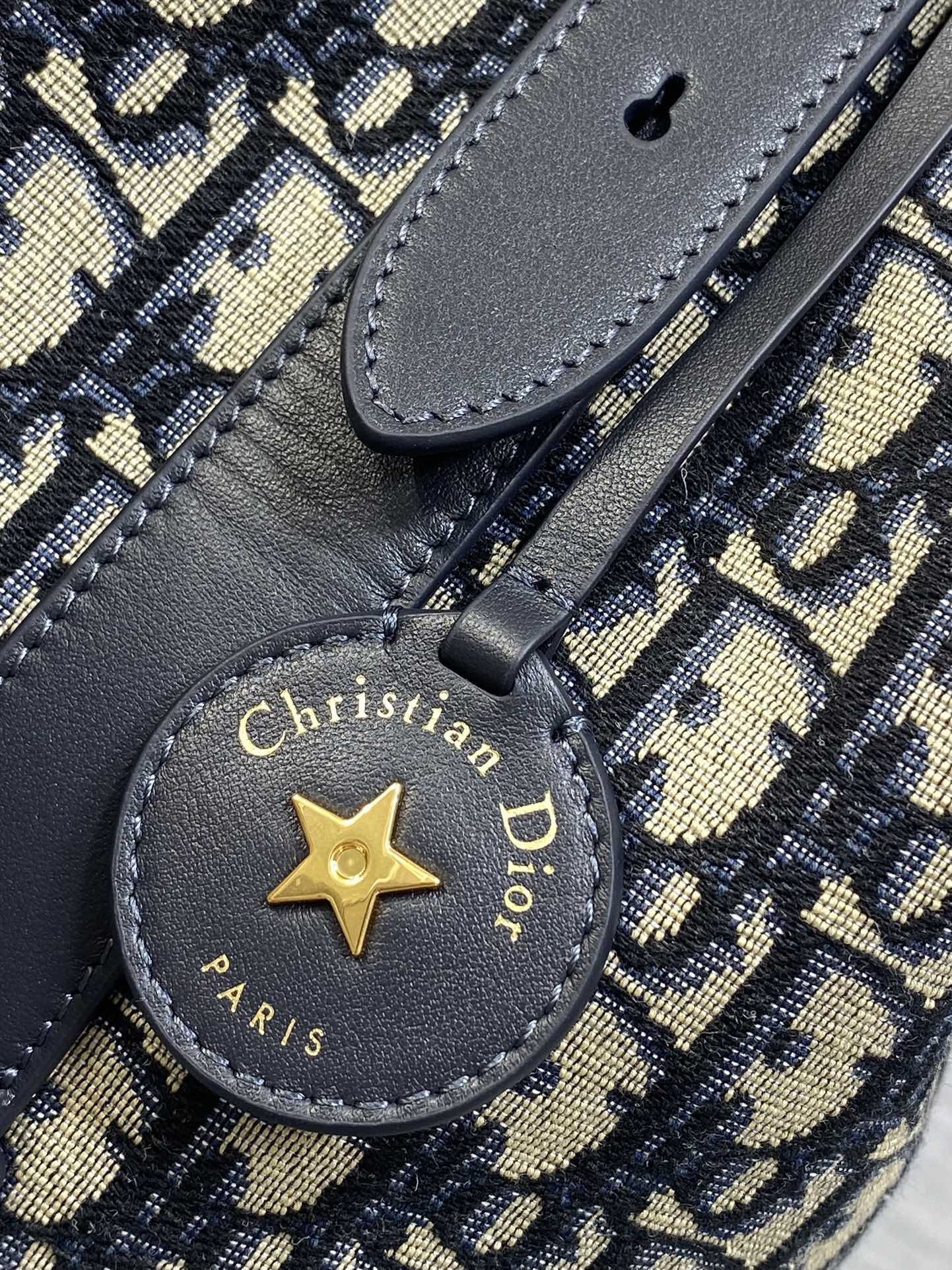 Christian Dior Paris star charm on navy leather strap with 'Made in Italy' text