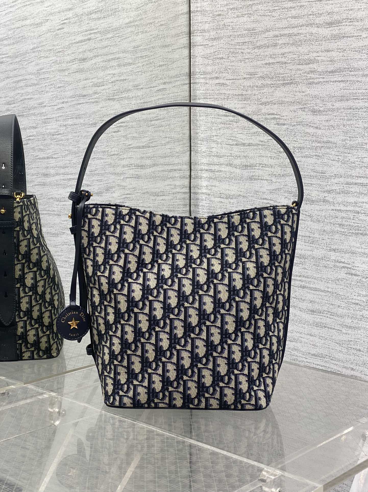 Dior Oblique canvas shoulder bag with navy trim and top handles, star charm at side