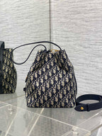 Dior Oblique canvas drawstring bucket bag with navy shoulder strap and gold clasp