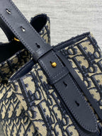 Dior canvas bag with navy leather straps and gold-tone hardware, close-up