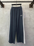 Balenciaga track pants in dark blue with white side stripes and drawstring hem