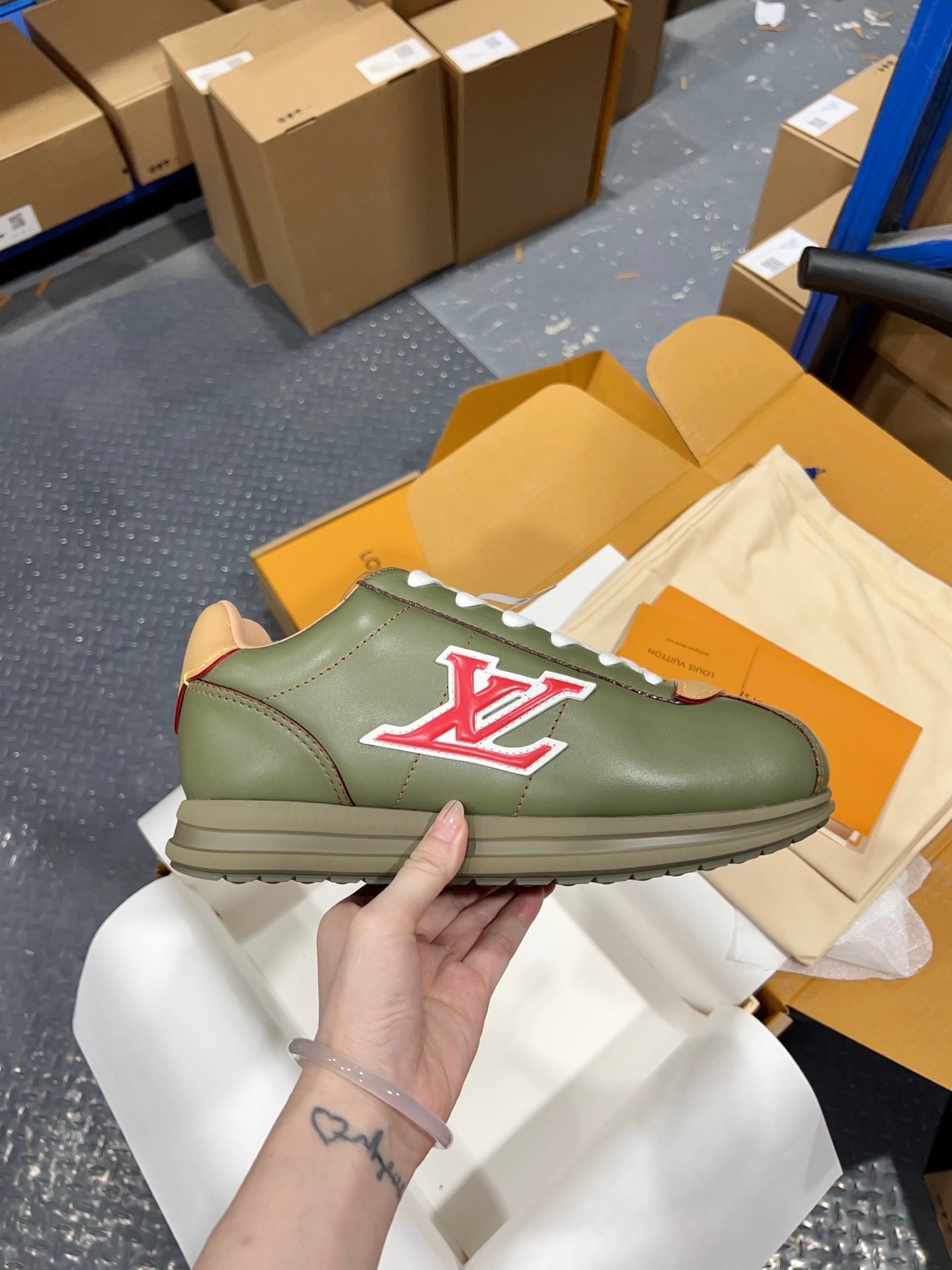 Green leather sneakers with lace-up top, embossed side logo, and light sole