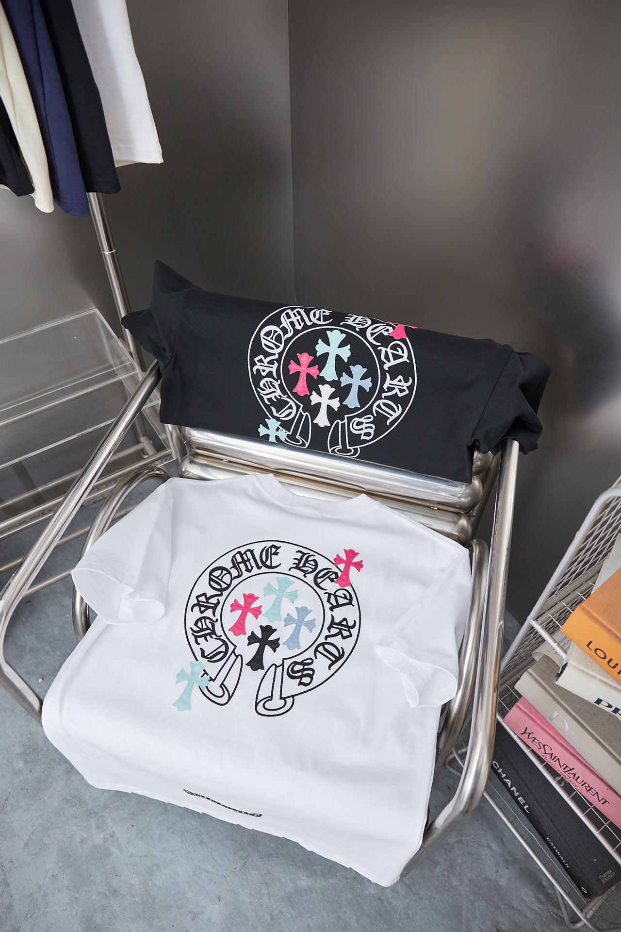Black and white short-sleeve T-shirts with circular crest logos on a metal rack