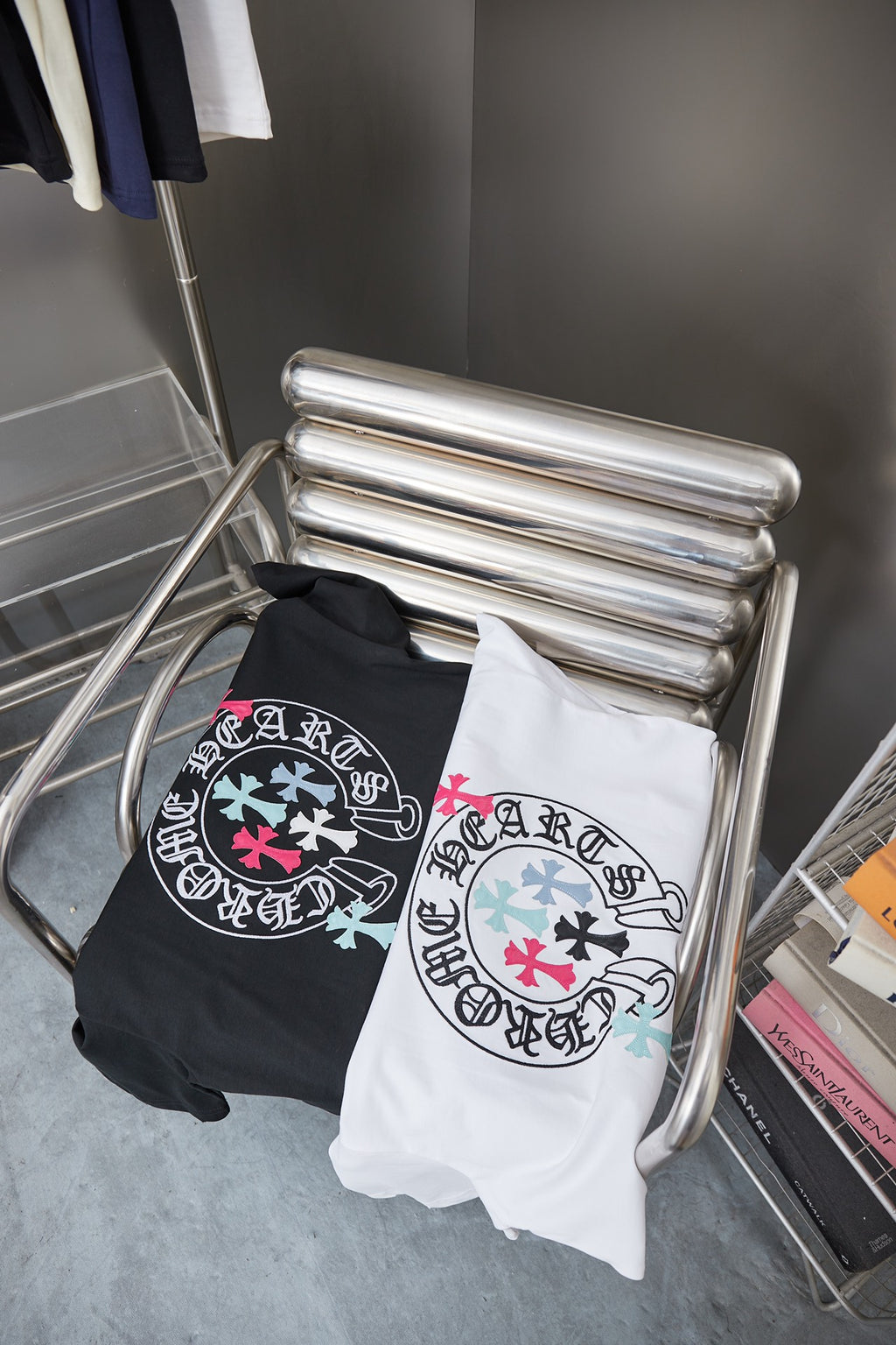 T-shirt pack on rack with white and black tops, both featuring circular logo graphics
