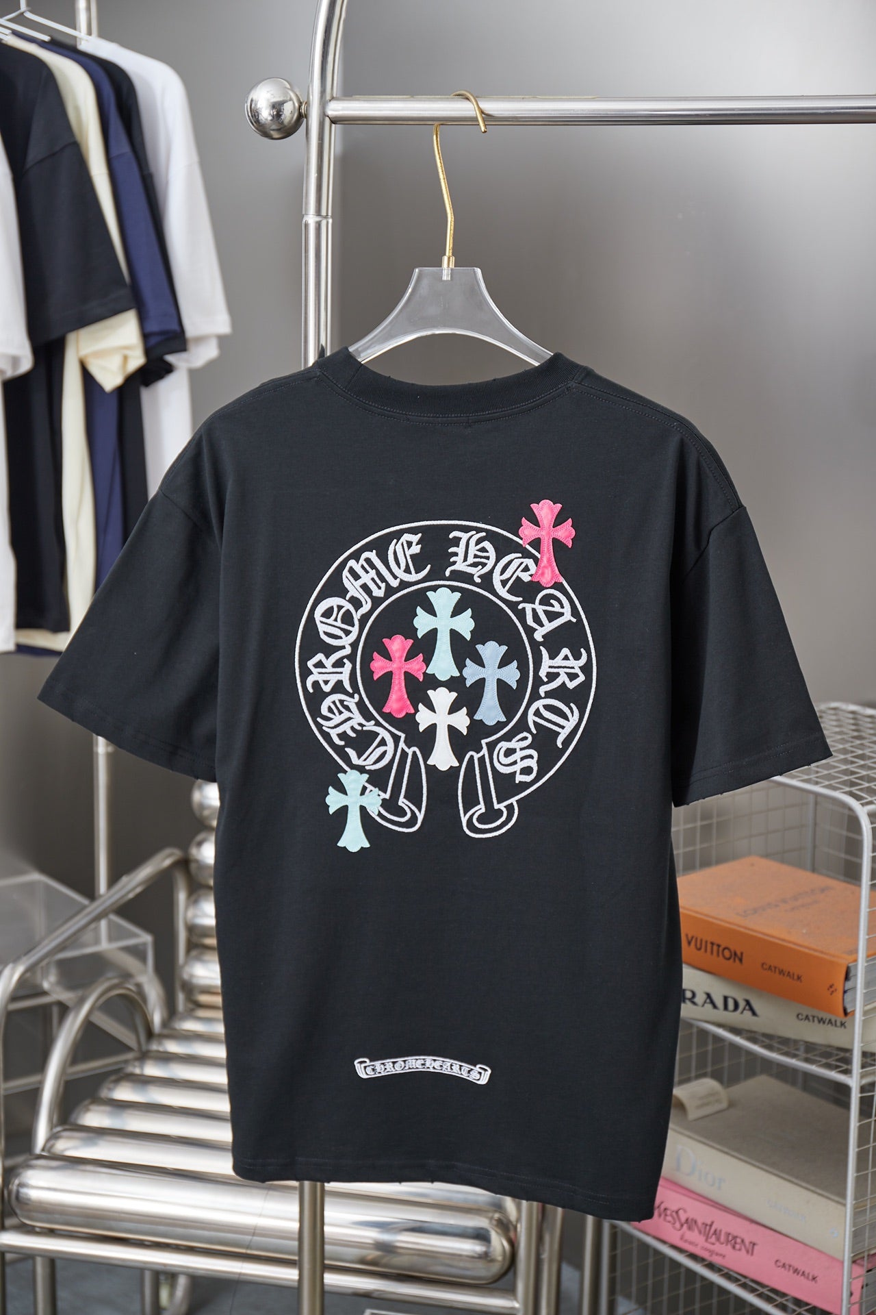 Black short-sleeve T-shirt with large circular logo and pink cross detail