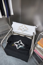 Folded Louis Vuitton T-shirt set on rack: white and black shirts with logos