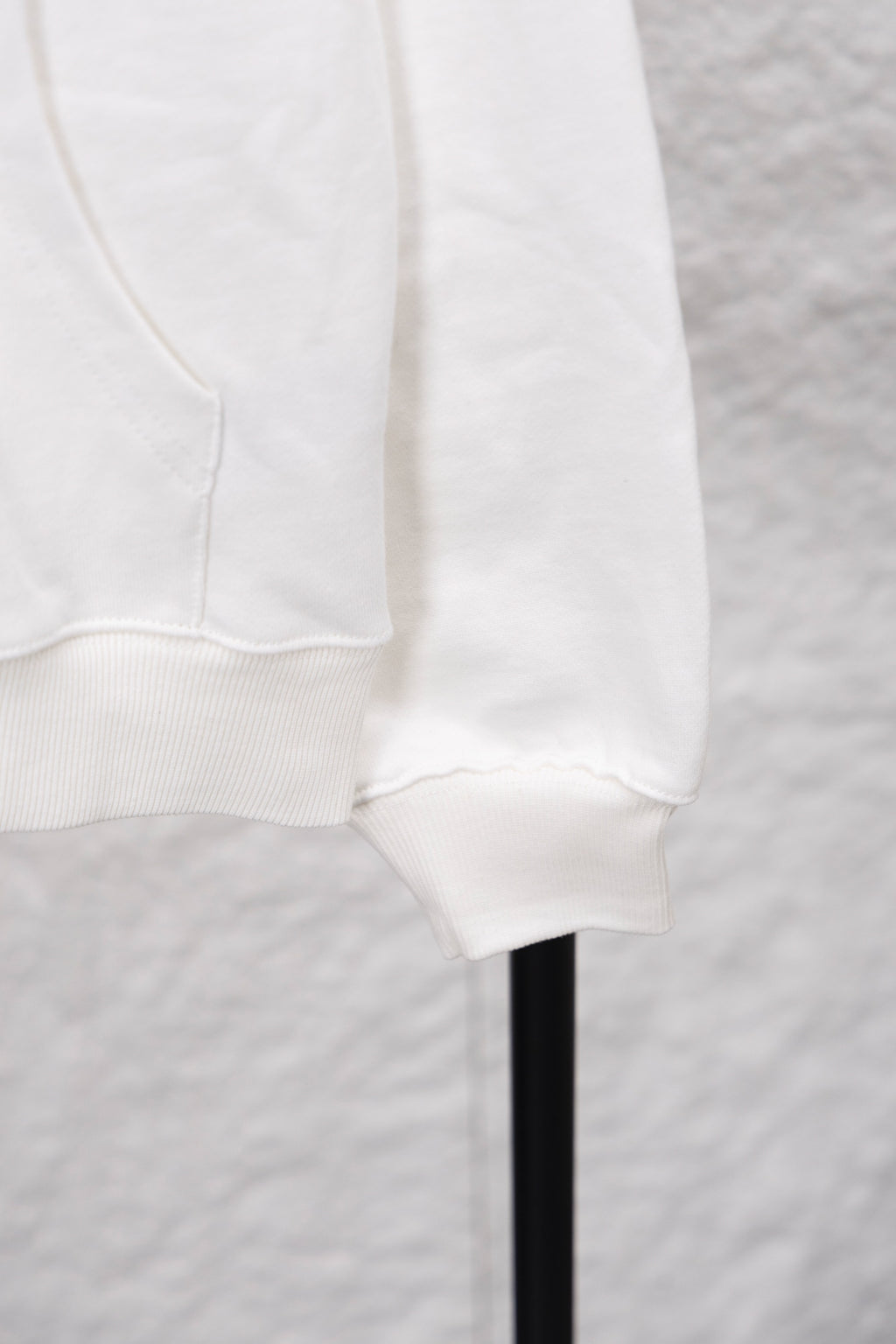 White hoodie cuff area with kangaroo pocket seam