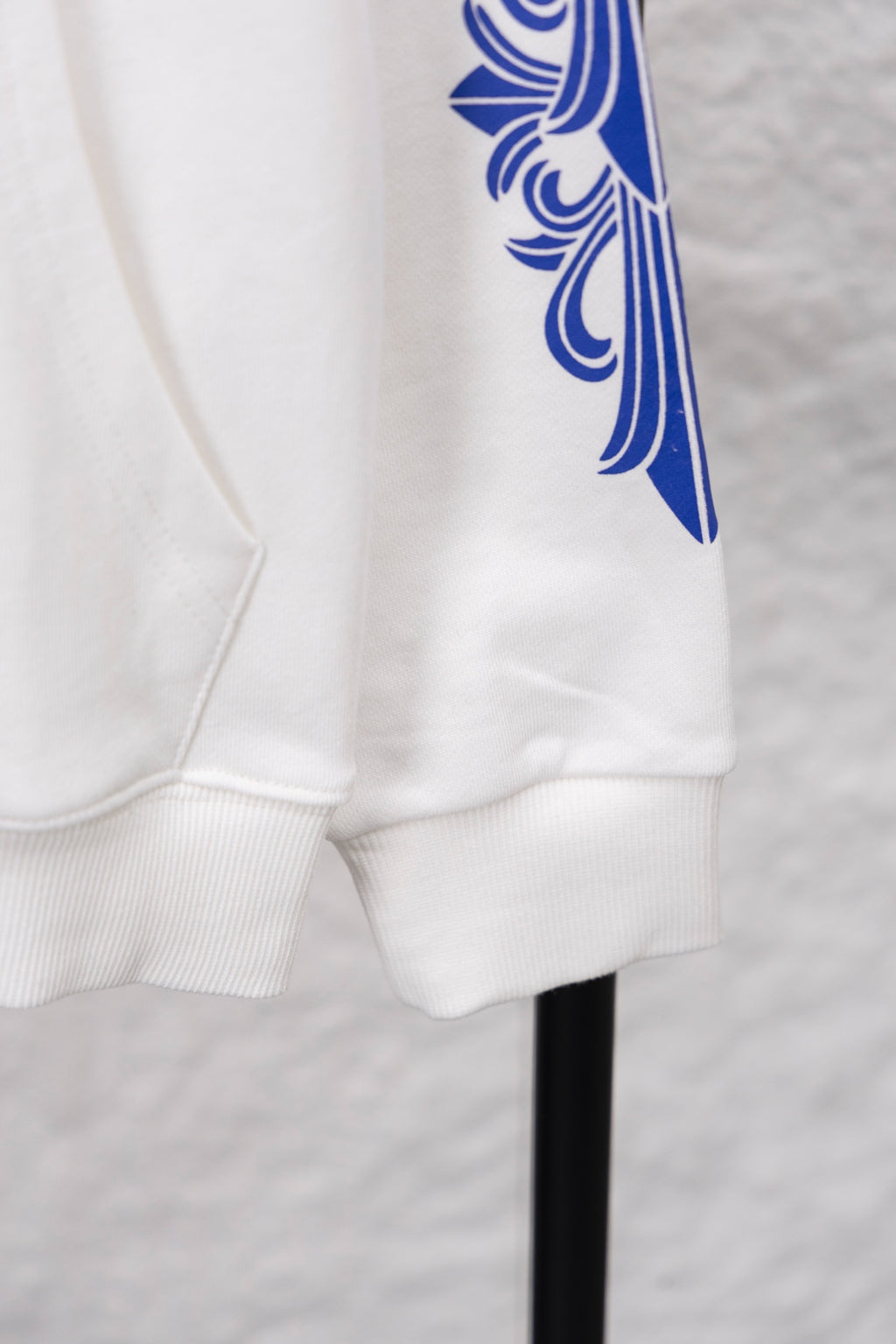 White hoodie cuff and pocket area with blue sleeve graphic print