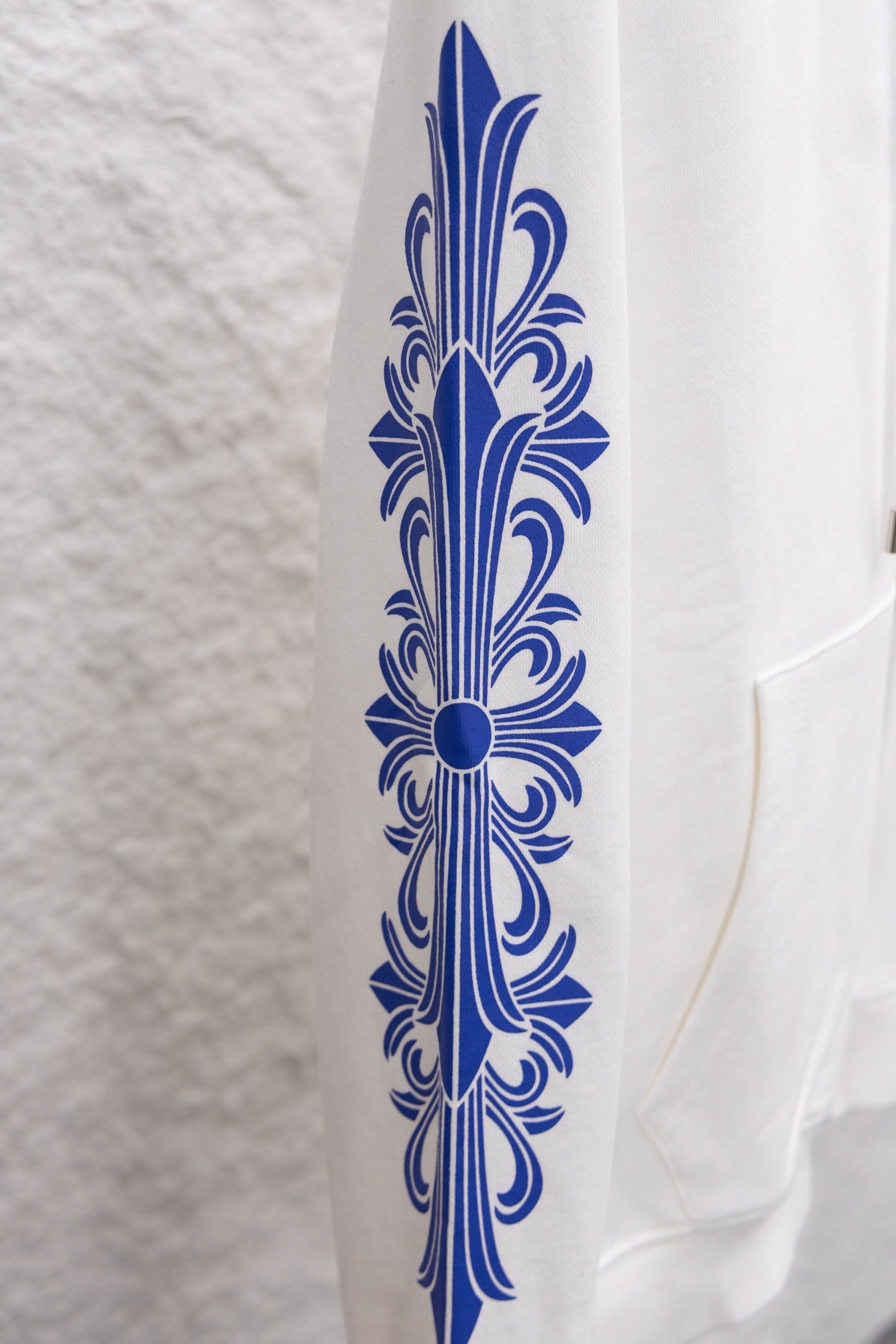 White long-sleeve sweatshirt sleeve with blue ornate print