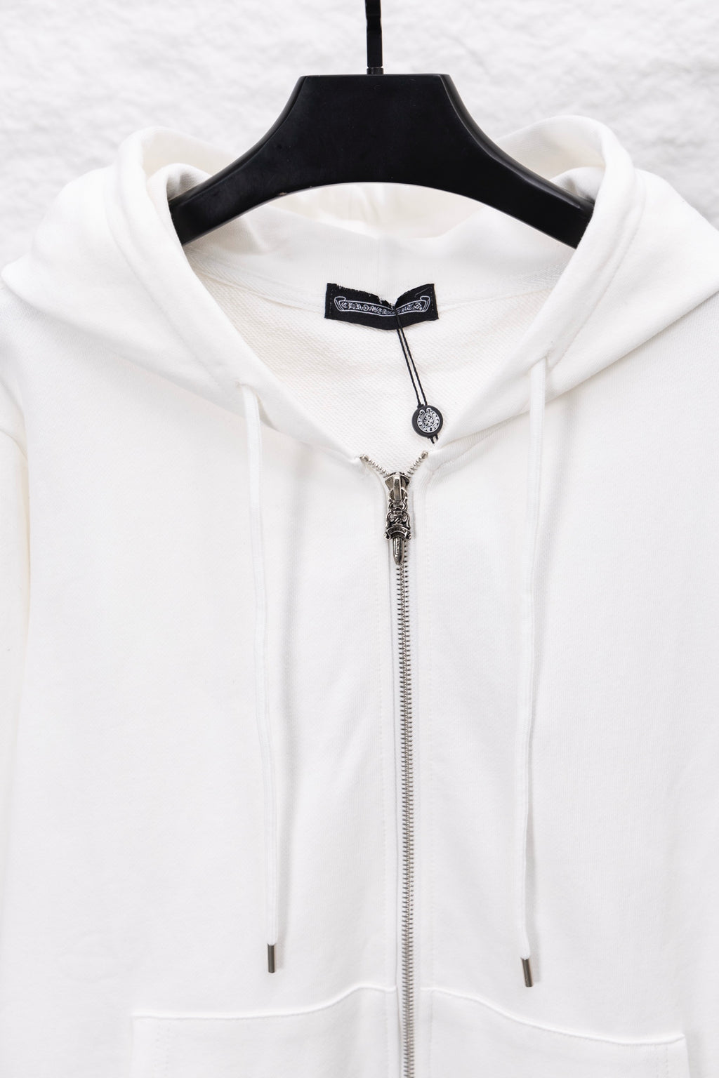 White zip-up hoodie with hood drawstrings and metallic zipper front