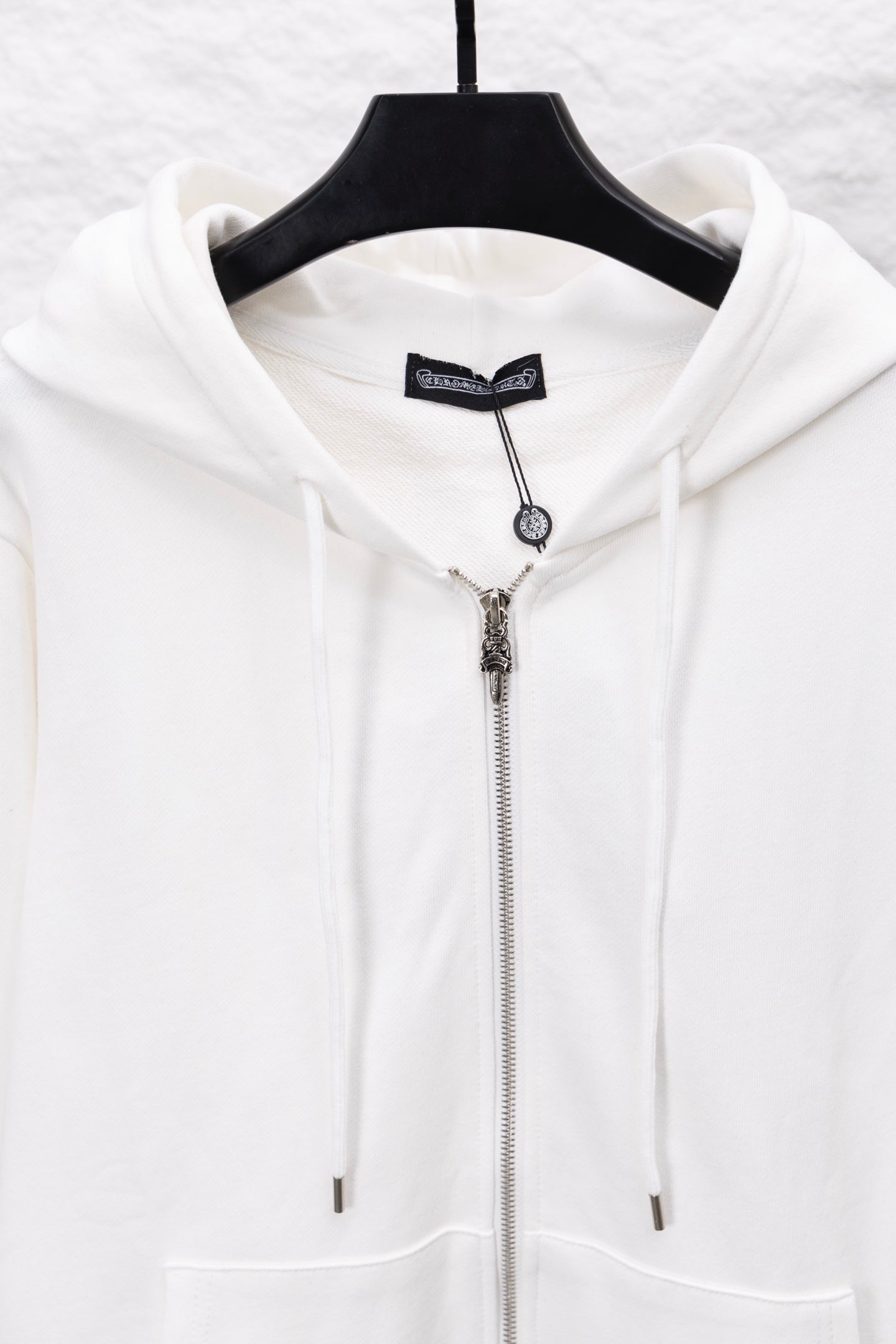 White zip-up hoodie with hood drawstrings and metallic zipper front