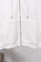 White zip-up hoodie front with kangaroo pockets and zipper center seam