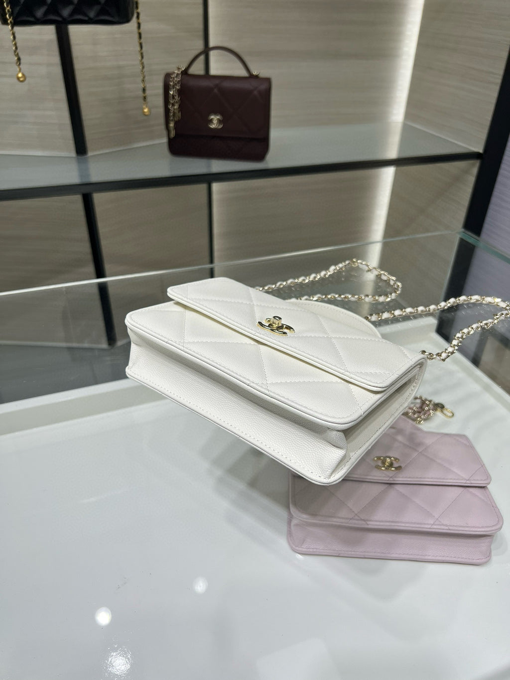 Stacked white and lavender quilted flap shoulder bags with gold clasps