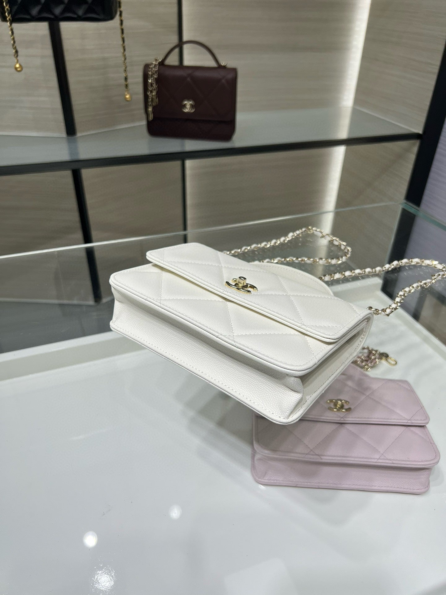 Stacked white and lavender quilted flap shoulder bags with gold clasps