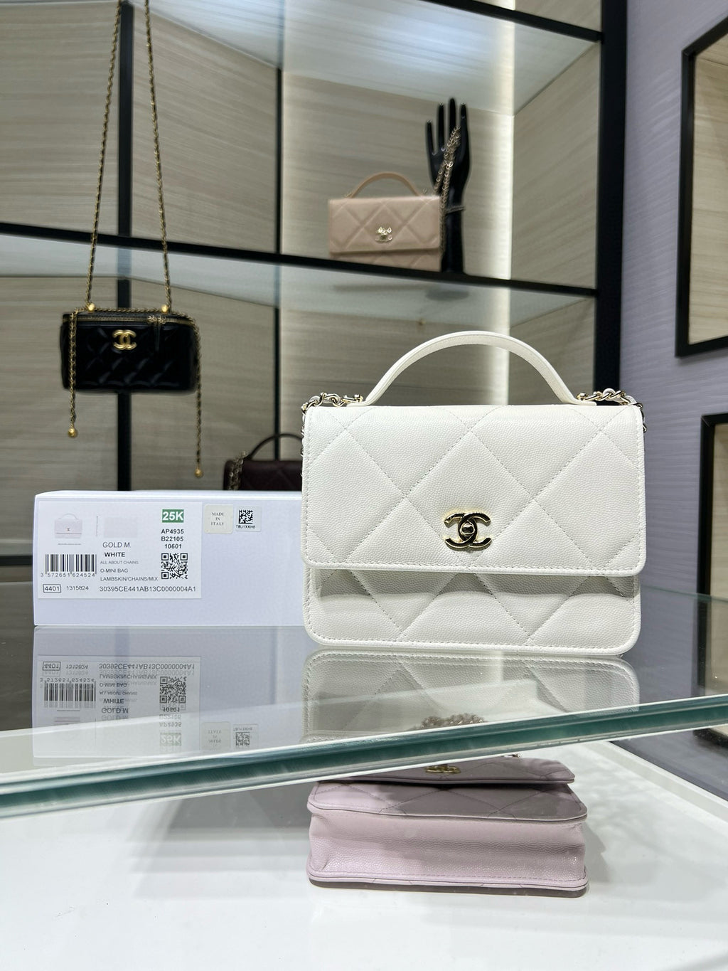 White quilted shoulder bag with top handle, flap, and gold CC turn-lock clasp