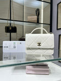 White quilted shoulder bag with top handle, flap, and gold CC turn-lock clasp
