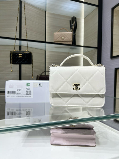 White quilted shoulder bag with top handle, flap, and gold CC turn-lock clasp
