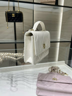 White quilted shoulder bag side view with top handle and gold CC clasp