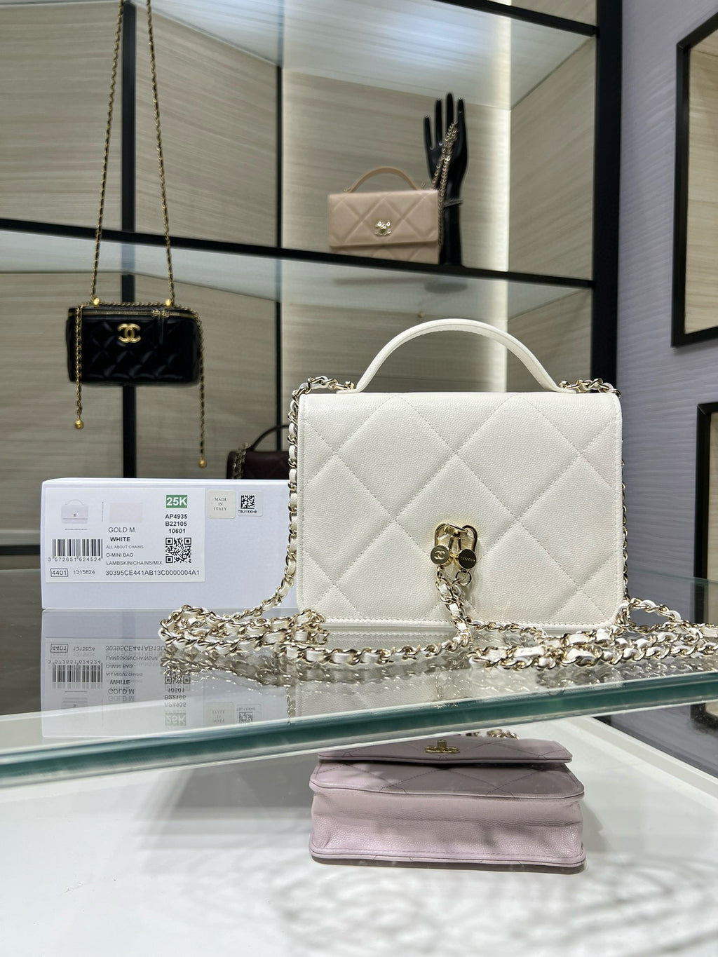White quilted shoulder bag with gold CC clasp and chain strap draped across