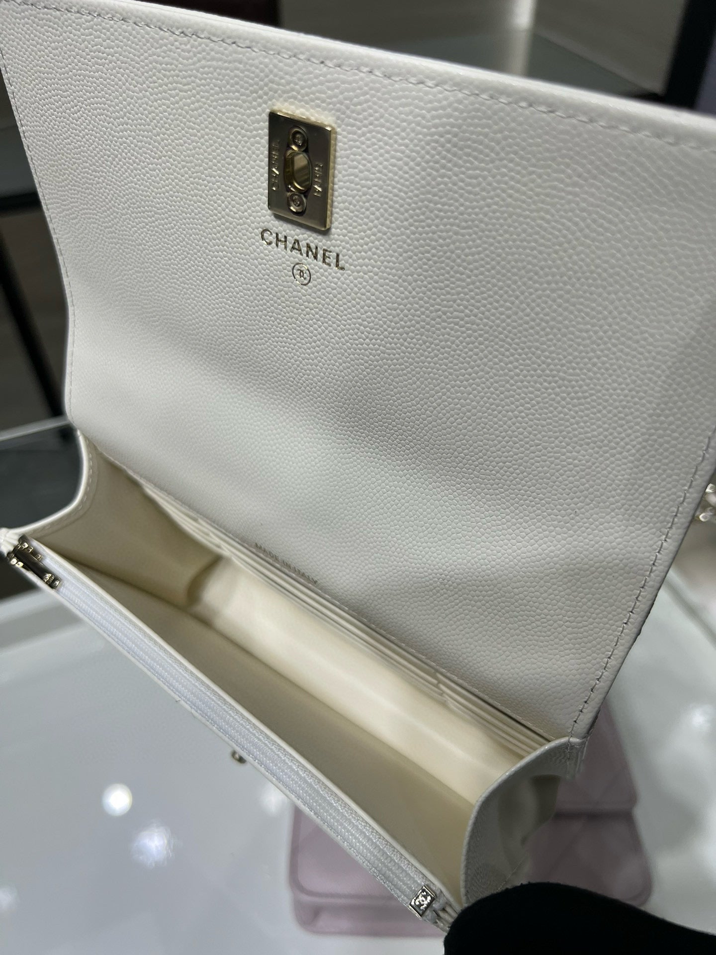 White pebbled leather bag with gold Chanel label plate and chain strap